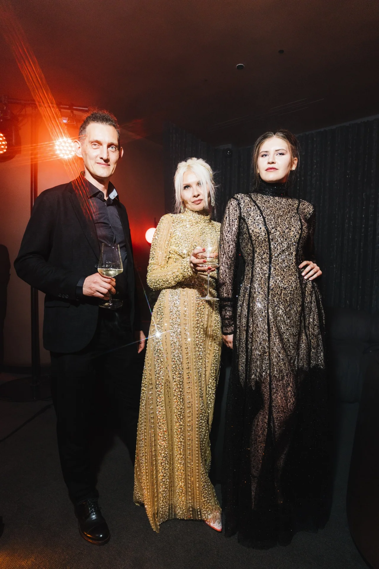 Dress code LE RITUEL ROUGE: мужчина в чёрном костюме и две девушки в вечерних образах